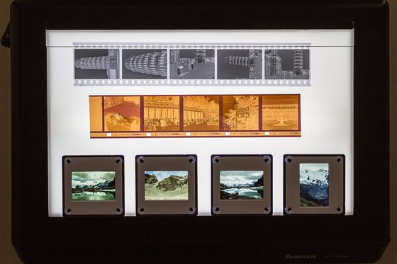 Black-and-white and colour film negatives and mounted slides on a lit light box