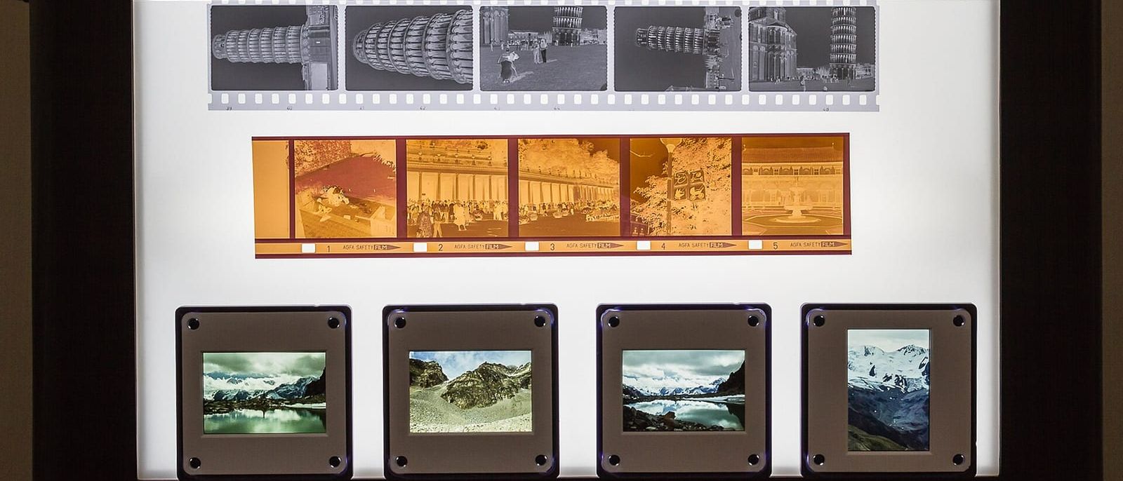 Black-and-white and colour film negatives and mounted slides on a lit light box
