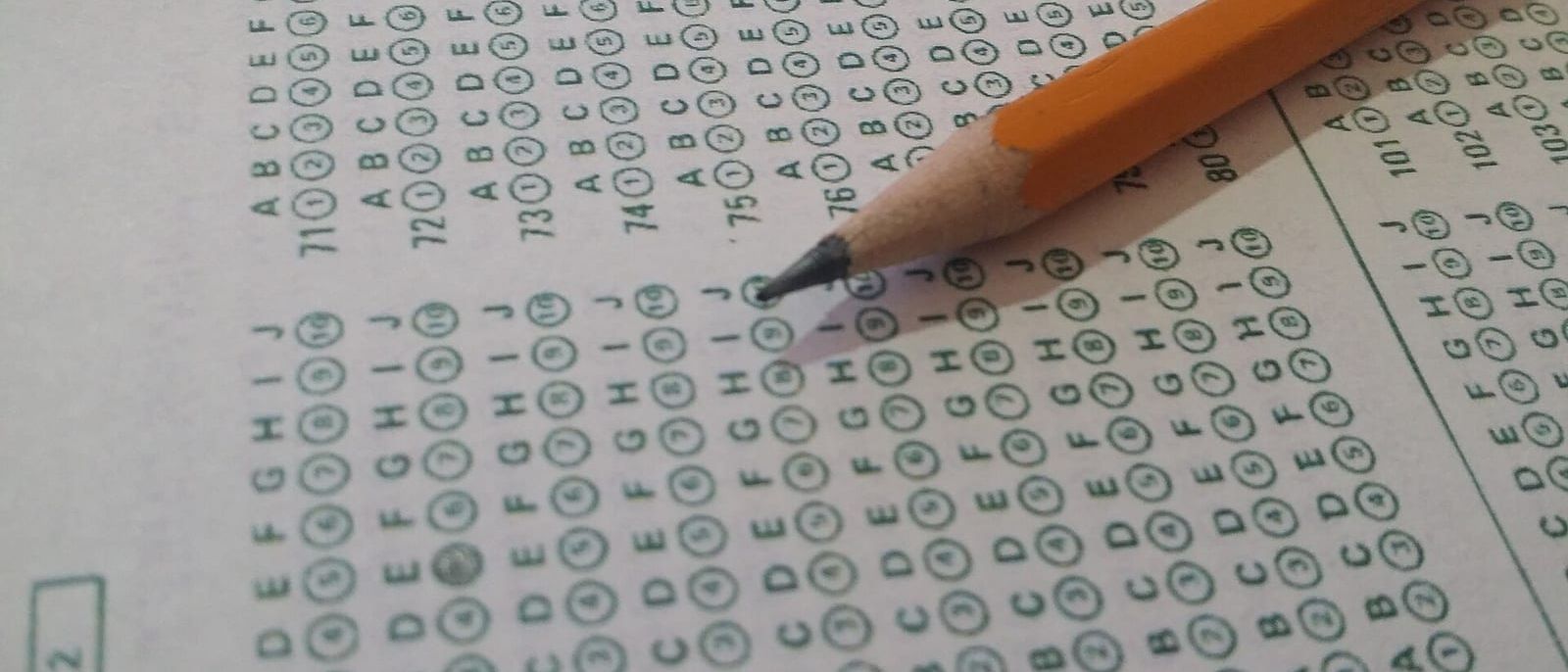 Pencil resting on a multiple-choice answer sheet with numbered bubbles